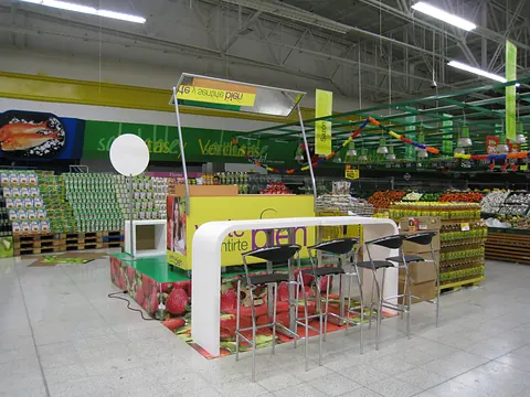 Mueble de degustación con sillas altas en el pasillo de un supermercado