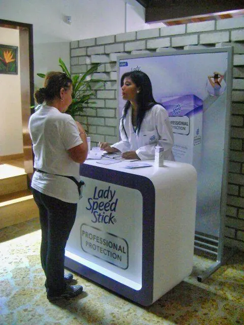 Promotora atendiendo a una clienta en un mueble de Lady Speed Stick