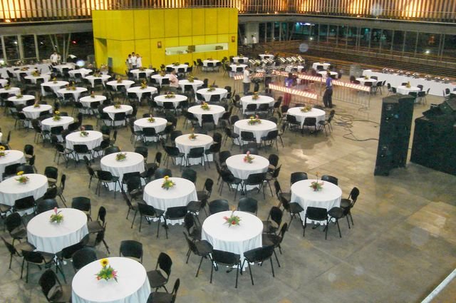 Montaje de mesas redondas con mantelería blanca y centros de mesa florales